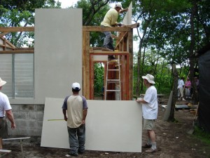 Jim Bowman helping the locals attach a wall panel